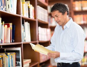 Casual man at the library reading a book
