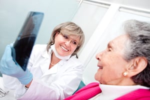 Dentist with an elder female patient looking at an x-ray-1