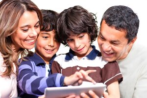 Family holding a tablet computer and looking at it