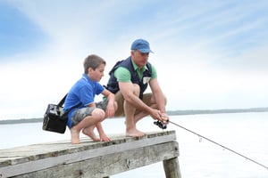 grandfather and grandson fishing in lake