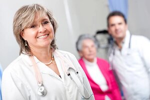 Geriatric female doctor smiling with an elder patient at the hospital