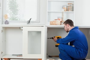 handyman installing new cabinets in kitchen with drawers