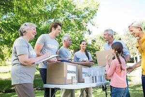 Happy volunteer family separating donations stuffs on a sunny day