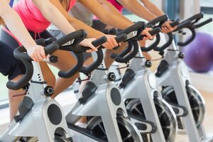 Mid section of four people working out at a class in gym