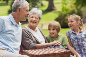 Portrait of a smiling senior couple and grandchildren at the park-1