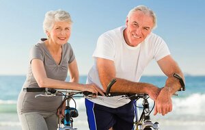 Retired couple with their bikes on the beach