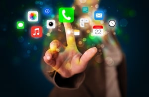 Businesswoman pressing colorful mobile app icons with bokeh background