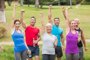 Happy athletic group holding up their fists om the park