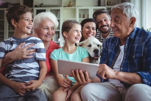 Happy multi-generation family using digital tablet in living room at home-1