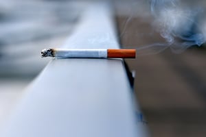 smoldering cigarette left on railing