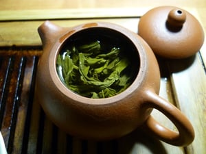 green tea with leaves in teapot