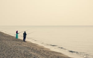 older couple fishing together on the beach