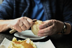 senior peeling orange by hand 