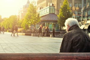 older man sitting alone on bench 