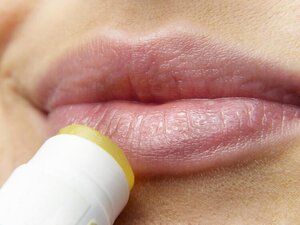 closeup of lips applying chapstick