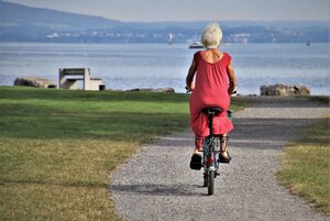 older woman riding bike in park