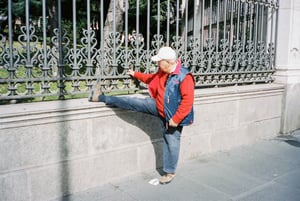 man stretching against wall on public street