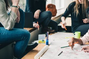 people at table drawing together