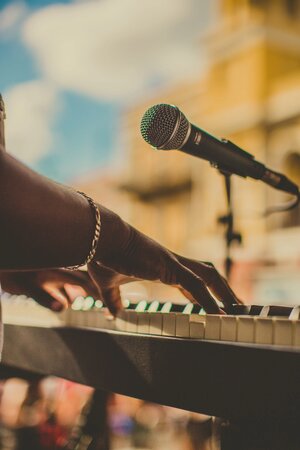 person playing piano and singing microphone