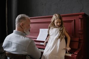 Grandfather playing piano with granddaughter 