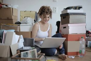 woman working on floor among boxes of clutter