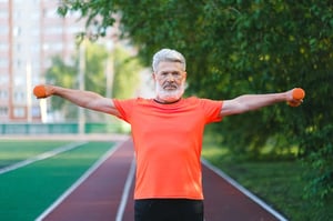 senior man lifting weights outdoors