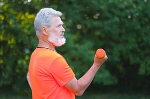 older man exercising biceps outdoors