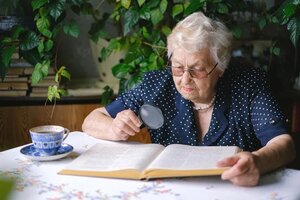 Retired woman reading at dining table