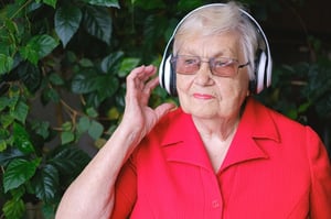 older woman listening to music with over the ear headphones