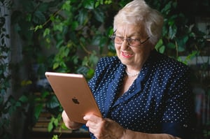 older woman reading blog posts on her ipad tablet