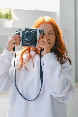 older woman taking picture with a camera