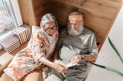 older couple sitting together reading book on daybet