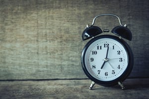 analog alarm clock over wooden background