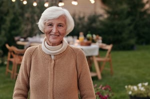 older woman standing in front of lighting hung in her backyard