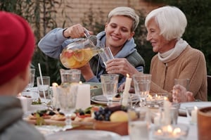 daughter pouring water for older woman in backyard