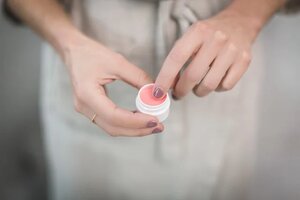 woman holding lip balm 