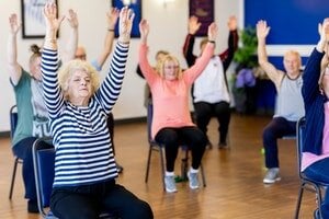 group of older adults performing chair exercises together
