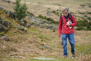 Older man walking outdoors with sunglasses