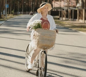 older woman biking with basket full of goods