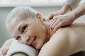 older woman receiving back and shoulder massage on table