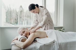 older woman receiving shoulder massage 