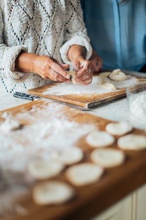 grandmother and daughter baking cookies together in kitchen