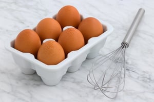 six eggs in carton and whisk