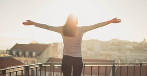 happy woman standing on balcony