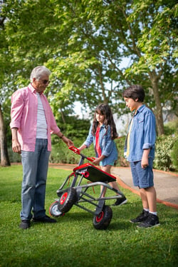 grandfather spending time with grandchildren playing with bike