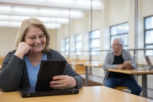 older woman smiling with ipad tablet