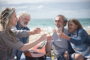 two older couples enjoying the beach in the winter together