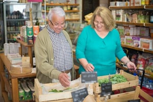 older couple shopping for produce together at local grocery store