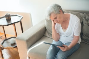 sad woman sitting on couch looking at photo