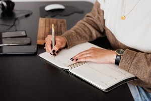 older woman writing in weekly planner